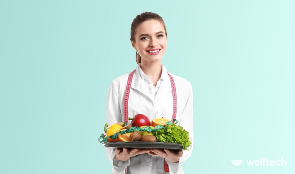 a woman dietitian is holding a plate with vegetables, questions to ask nutritionist