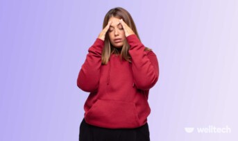 a girl in a red hoodie is experiencing fatigue and headache, holding her head, weight gain adrenal fatigue