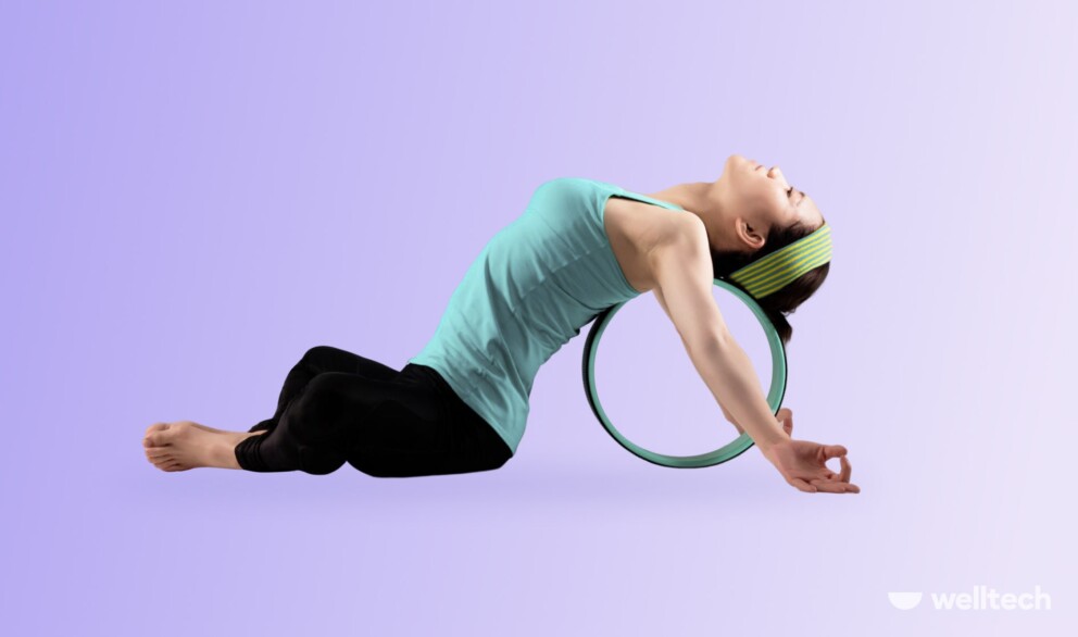 a woman is practicing yoga with a wheel, performing Reclined Bound Angle Pose (Supta Baddha Konasana)_yoga wheel stretches
