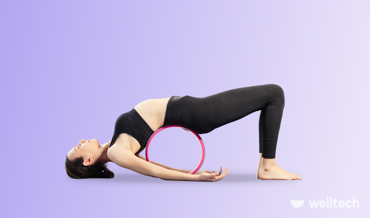 a woman is practicing Bridge Pose with a yoga wheel_yoga wheel stretches