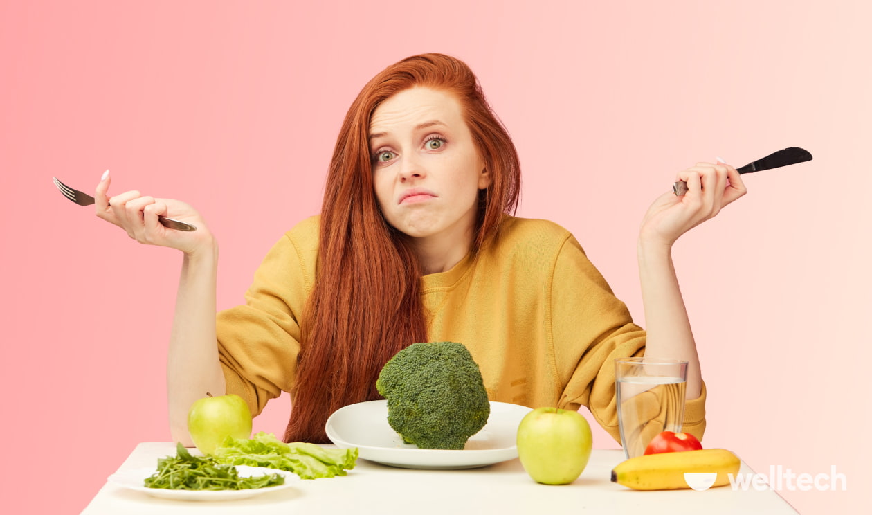 Fasting After a Cheat Day, a girl is sitting in front of a plate with broccoli on it