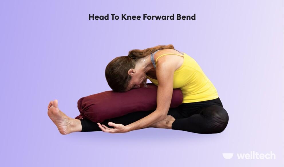 a woman is practicing restorative yoga_head to knee forward bend_yoga poses with a bolster