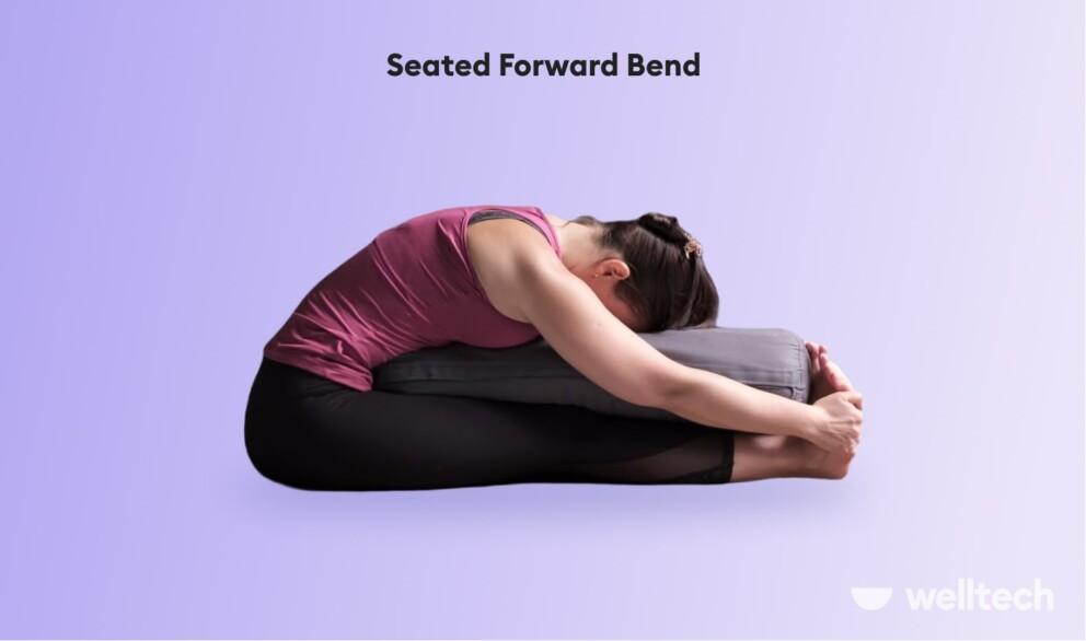 a woman is practicing restorative yoga_seated forward bend_yoga poses with a bolster