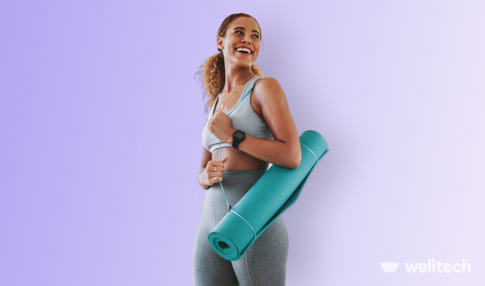 a woman in sportswear is holding a yoga mat on her shoulder_substitute for yoga mat