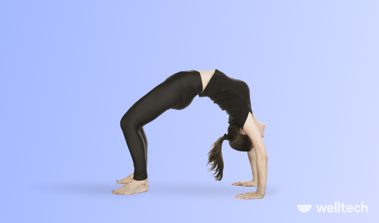 a woman is practicing yoga, doing Wheel Pose (Urdhva Dhanurasana)_yoga inversions