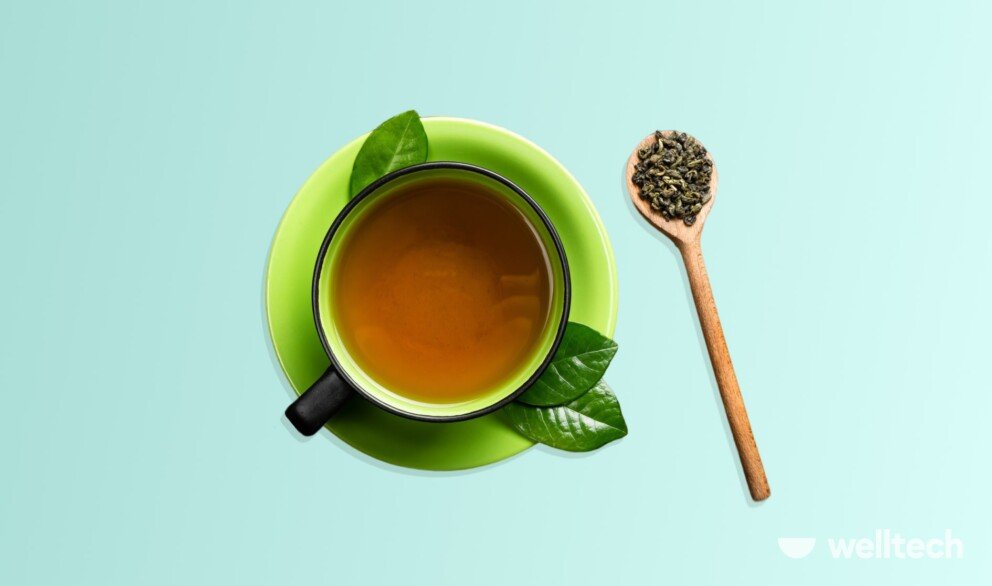 a cup of green tea with a wooden spoon with some dry tea leaves in it_can you drink tea while fasting
