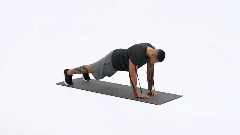 A man is performing lateral head tricep exercises using diamond push-ups with a band loop.