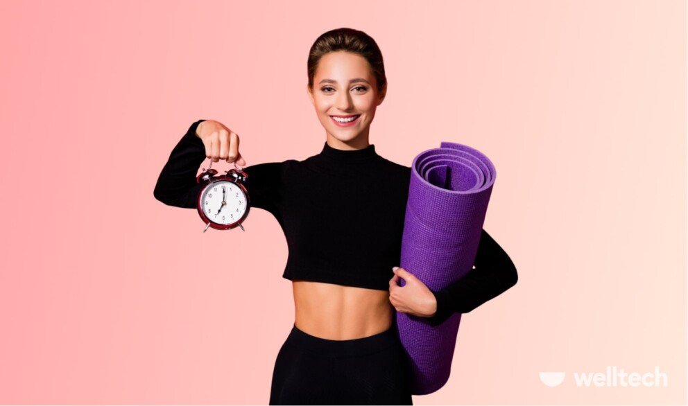 a young woman is holding a yoga mat and a clock, smiling, how long do you hold yoga poses