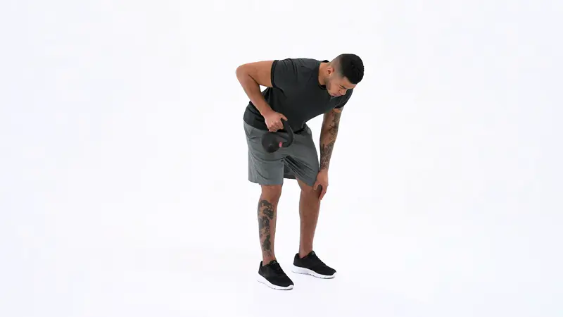 A man is performing lateral head tricep exercises using kettlebell tricep kickbacks.