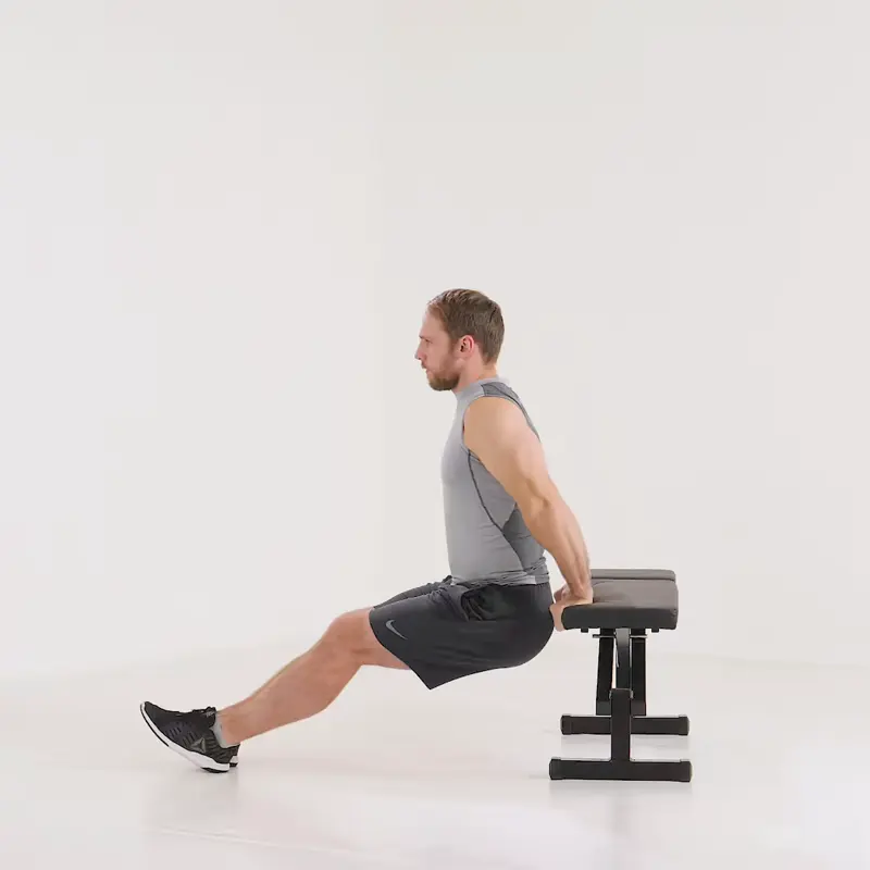A man is performing lateral head tricep exercises using bench dips.