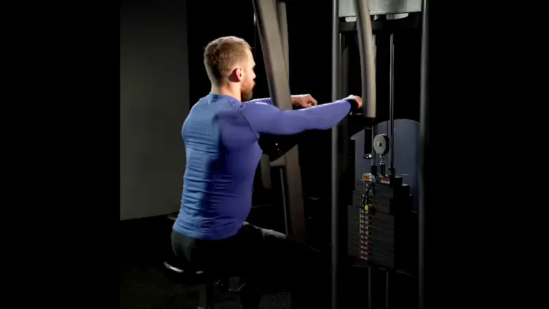 a man is performing rear delt fly machine variation in the gym