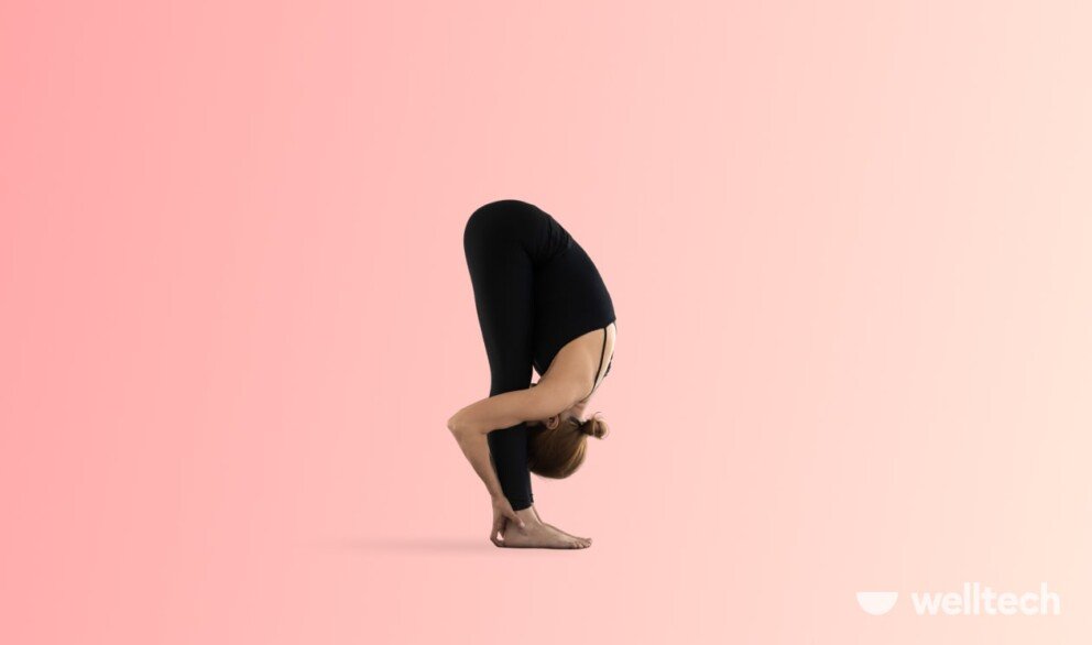 a woman is practicing yoga, doing Standing Forward Fold (Uttanasana)_weight-loss yoga poses