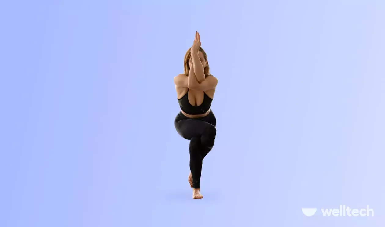 a woman is doing yoga, practicing Eagle Pose (Garudasana)_standing yoga poses