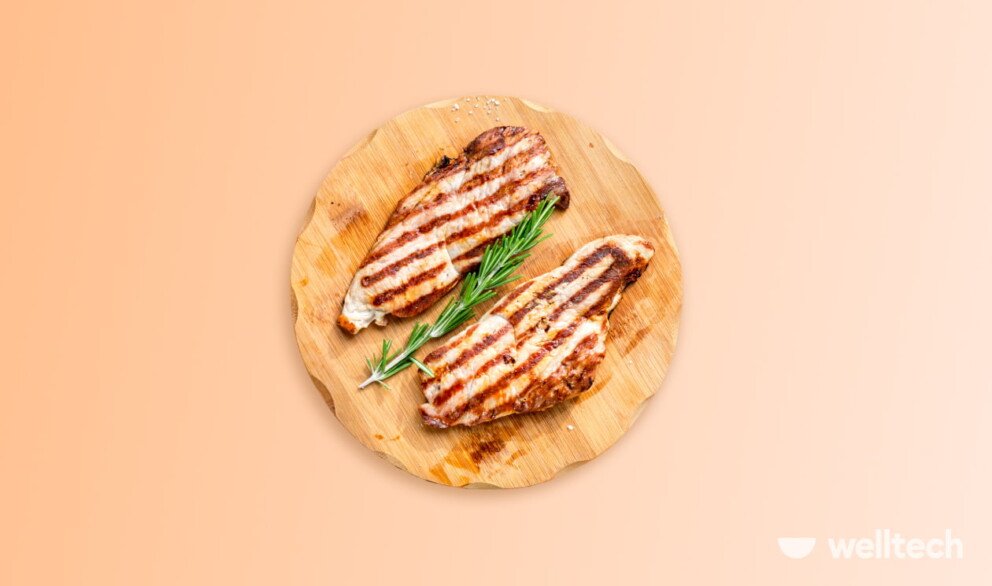 two grilled chicken breasts on a wooden board, protein in chicken breast