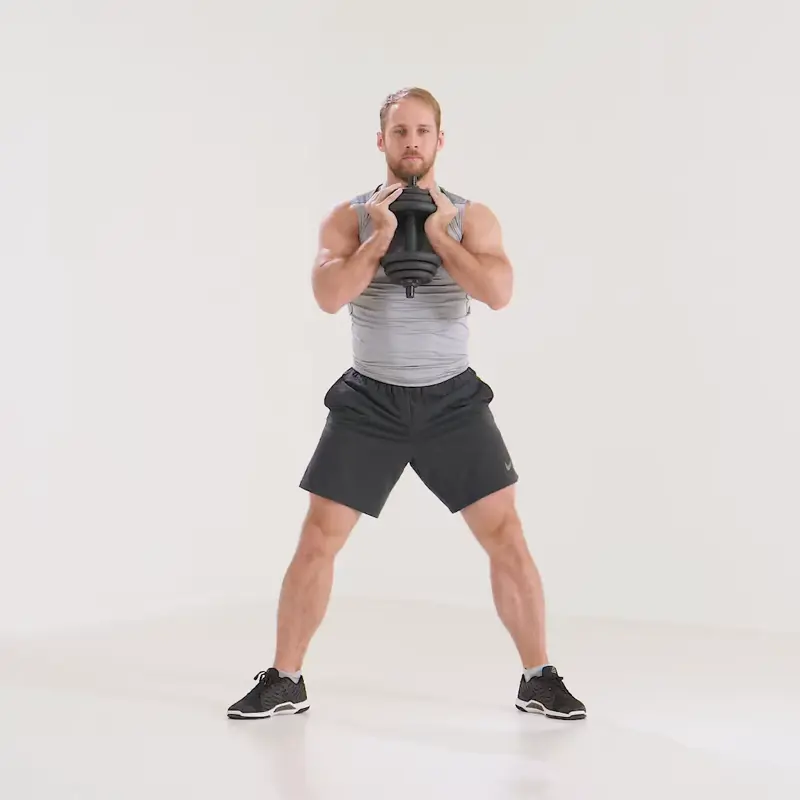 a man is performing goblet squat_beginner dumbbell exercises
