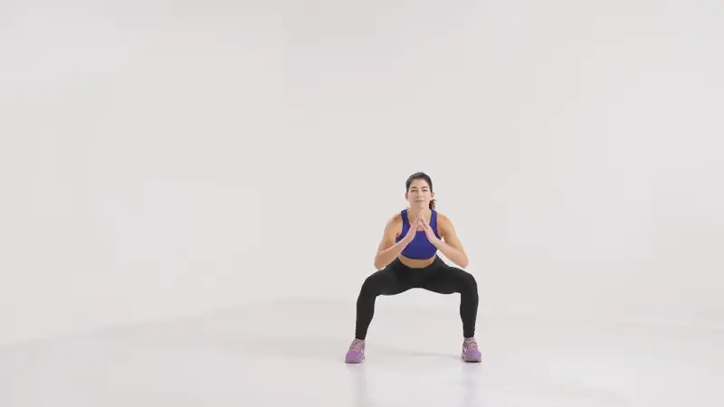 a woman is doing side jump to squat_knee fat exercises
