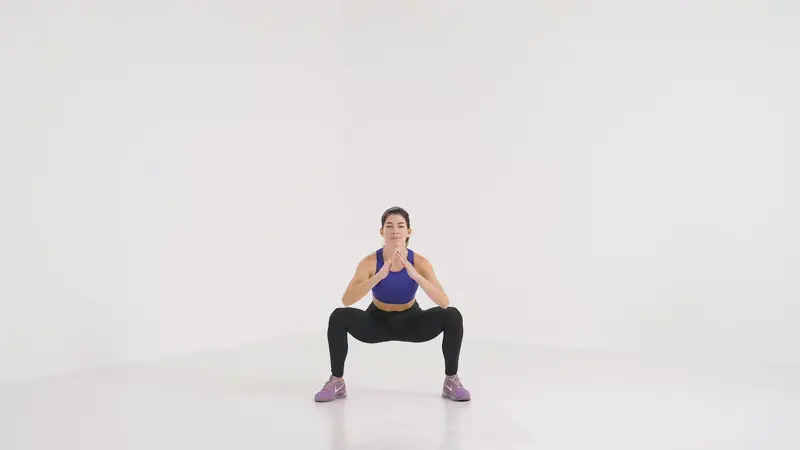 a woman is doing squat jumps_yoga sculpt