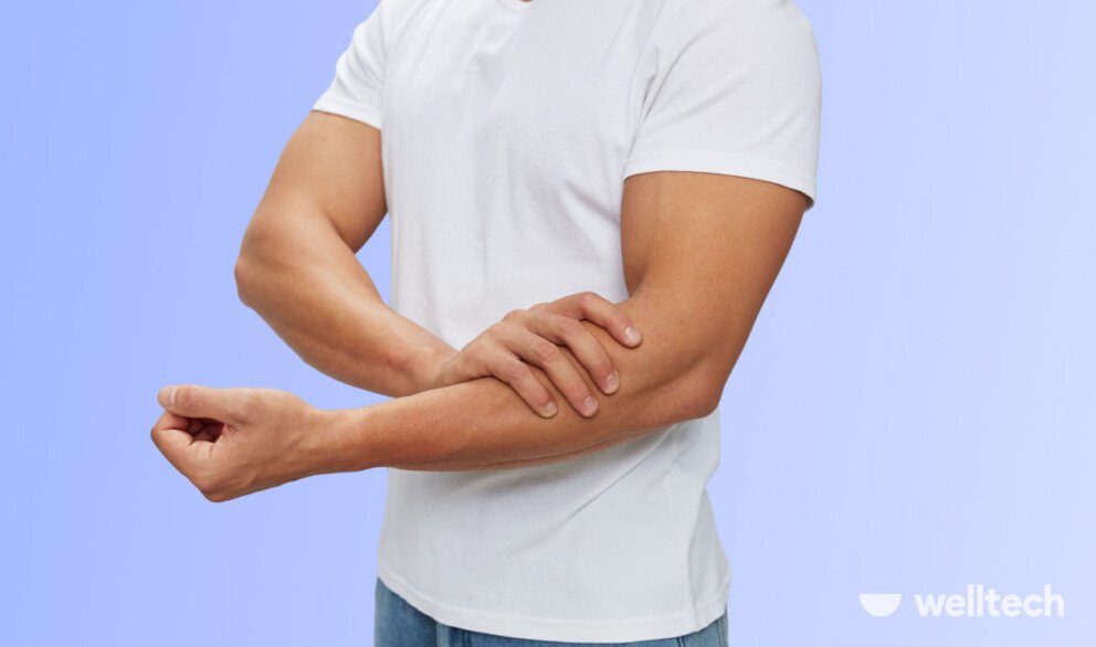 a man in white t-shirt is holding his hand below the elbow_can't straighten arm after workouts