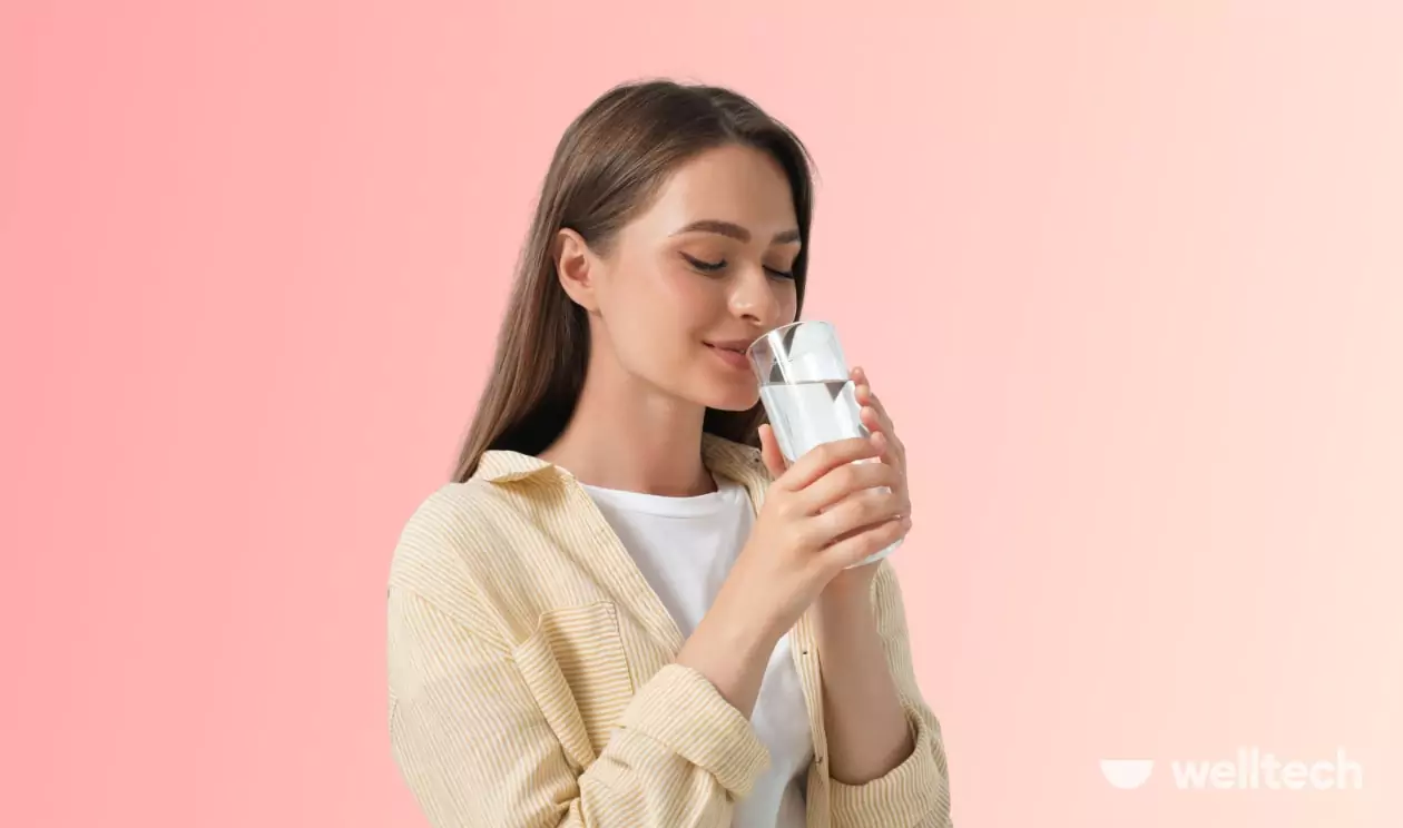 a young woman is drinking water from a glass, does warm water help you lose weight