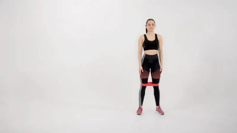a woman is performing lateral walks_side glute exercises