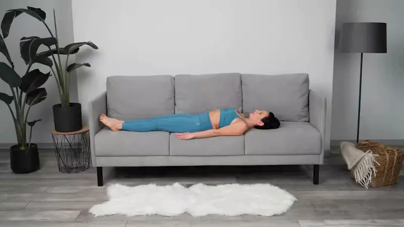 a woman is doing yoga in bed_sofa yoga_practicing Supine Lateral Stretch