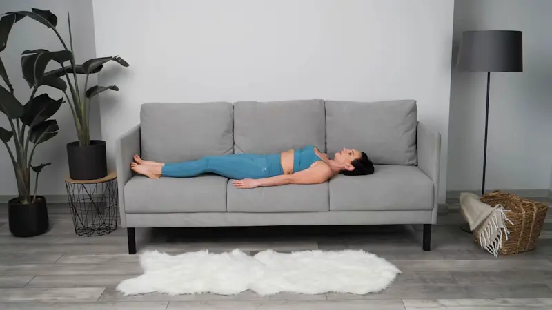 a woman is doing yoga in bed_sofa yoga_practicing Knee Hugs