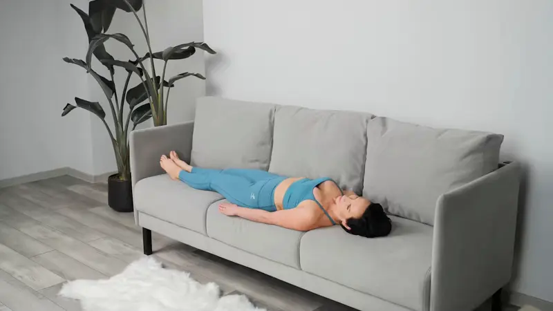 a woman is doing yoga in bed_sofa yoga_practicing Neck Rotations