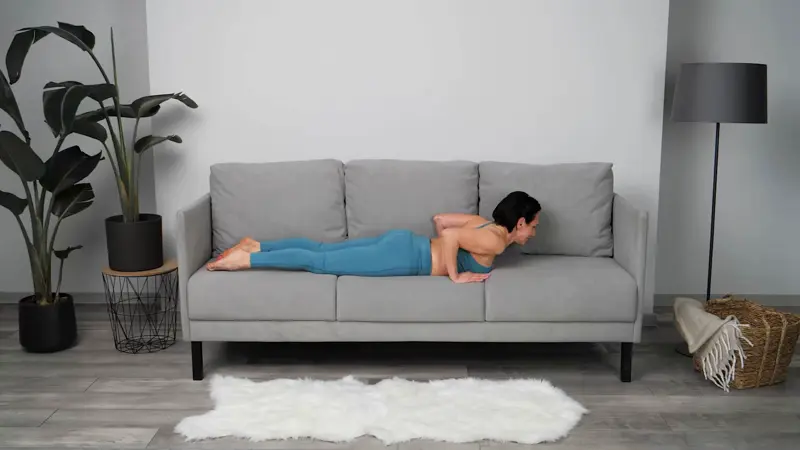 a woman is doing yoga in bed_sofa yoga_practicing Puppy Dog Pose