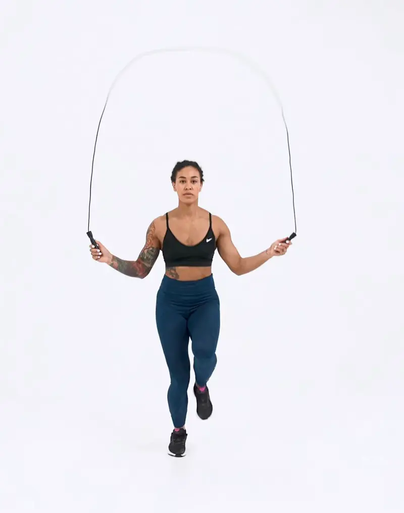 a woman is performing cardio legs workout, jumping rope with high knees