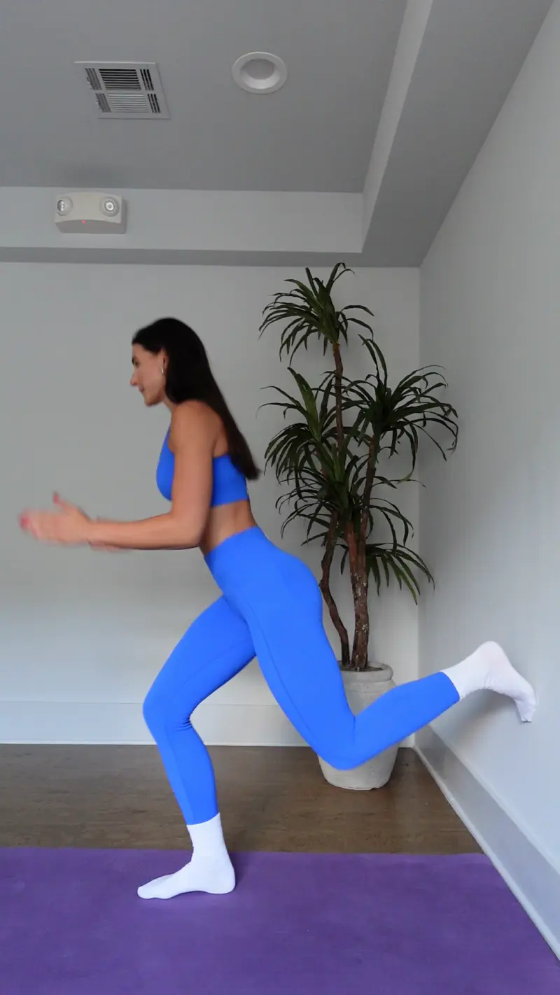 a woman is working out, doing Lunges_wall pilates