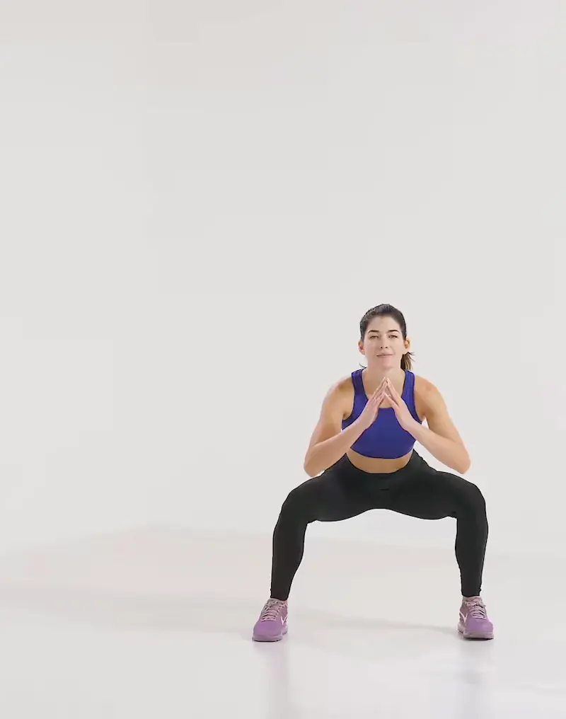 a woman is performing cardio legs workout, doing side jump to squat